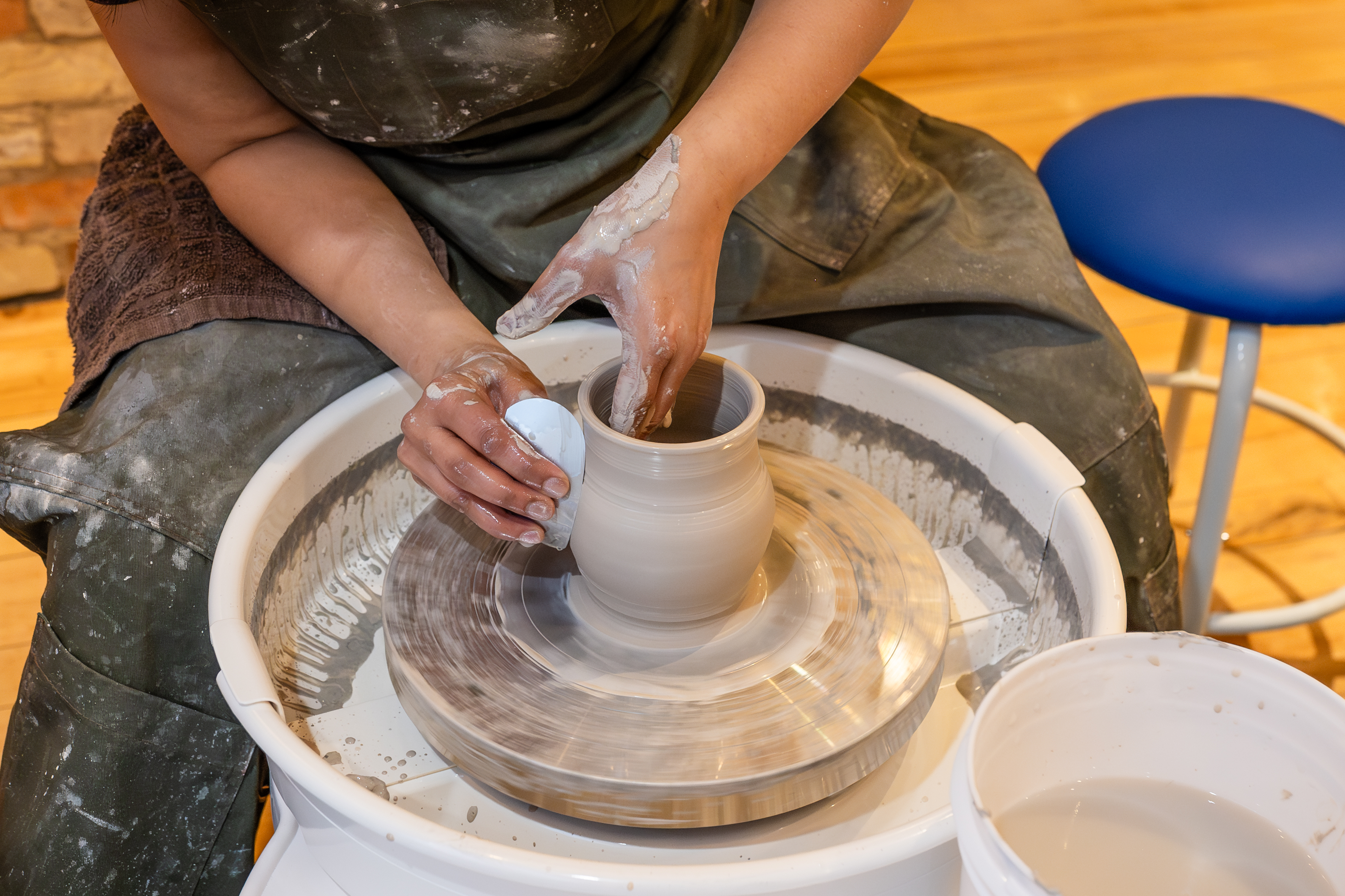 Pottery studio members working with clay at Spin Pottery Studio
