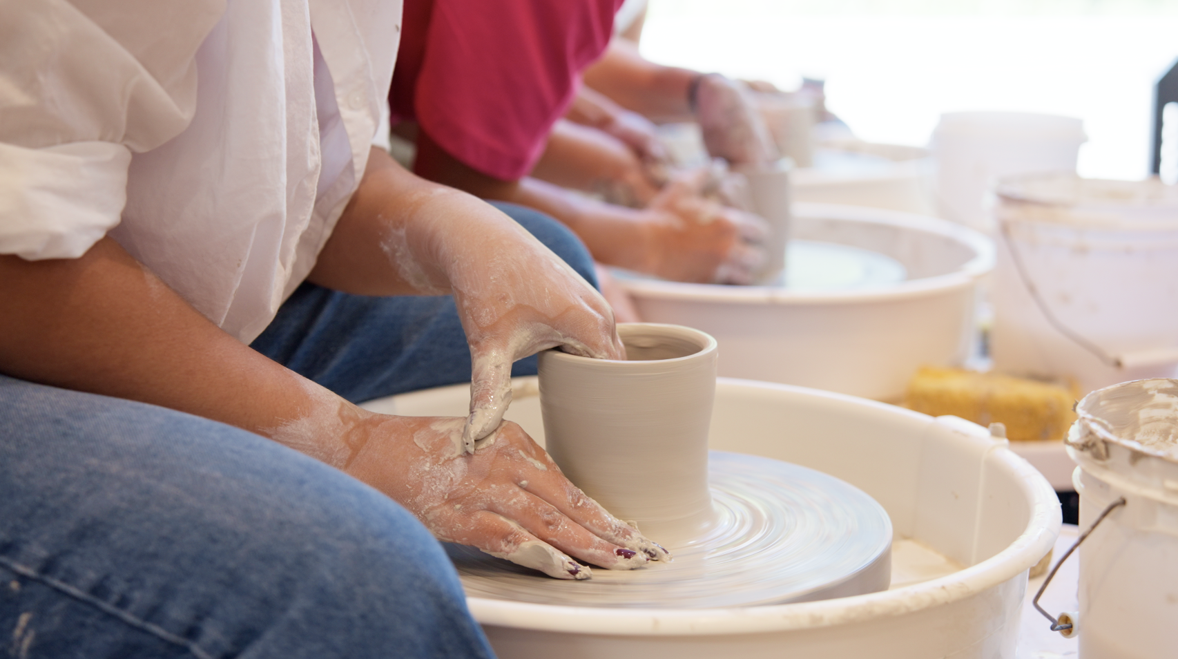 Student creating pottery on the wheel during a two-hour workshop at Spin Pottery Studio.