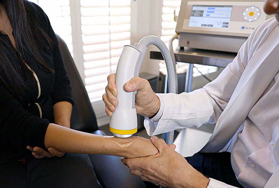 SoftWave therapy treatment being applied to a patient's shoulder area