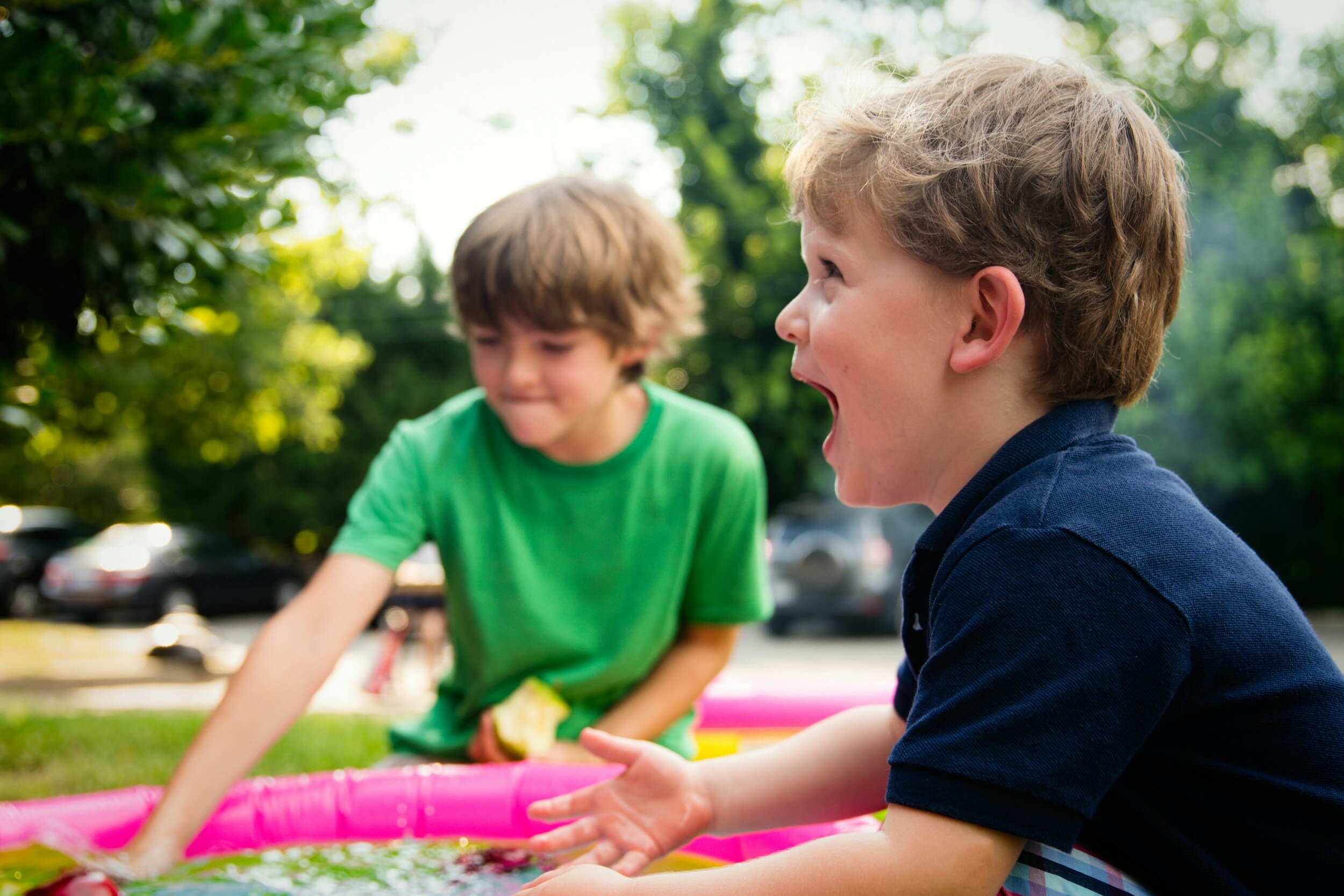 Two young boys playing and laughing outside on a sunny day, showing that treatment helps patients stay active