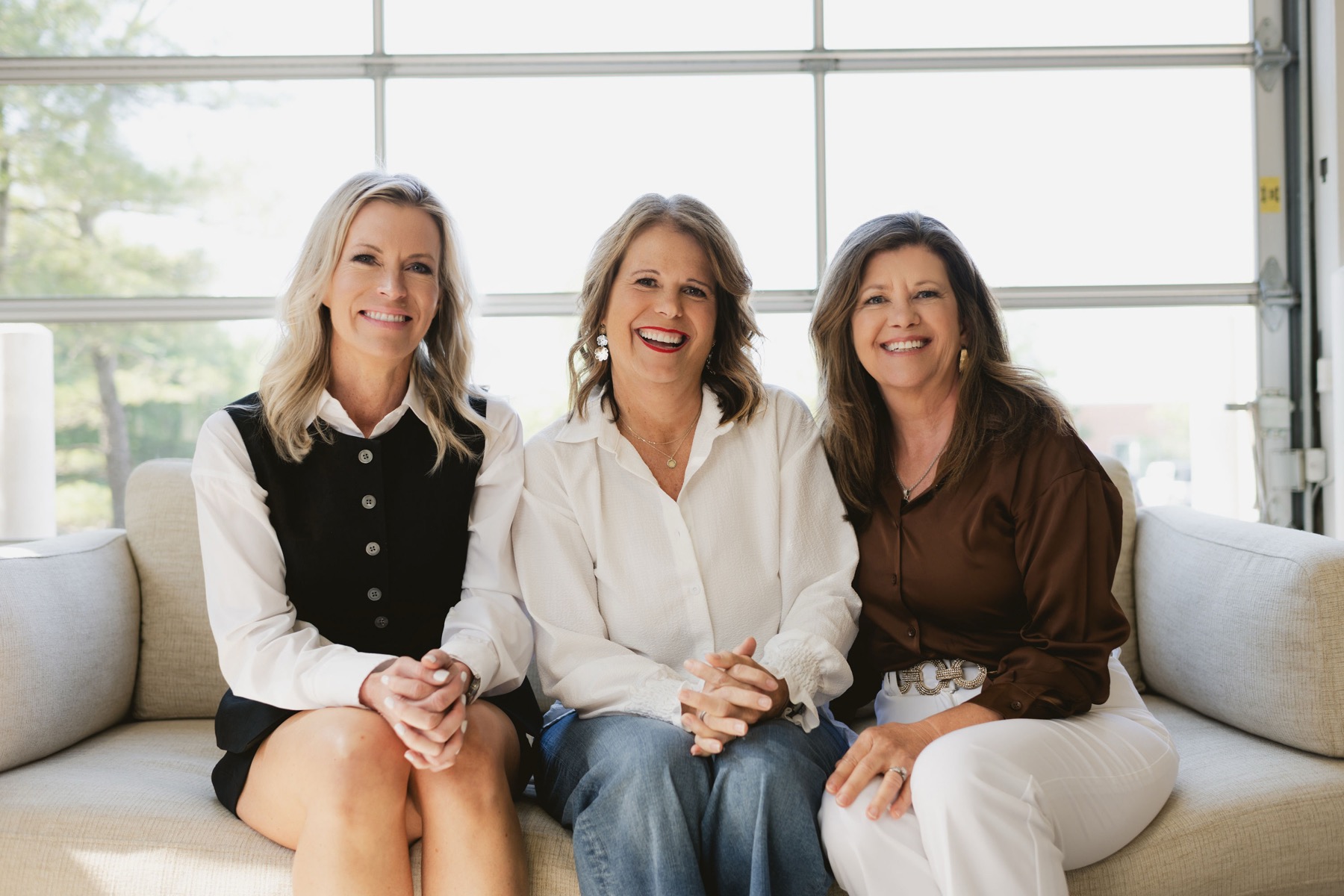 Laura Nelson laughing on a sofa with two friends