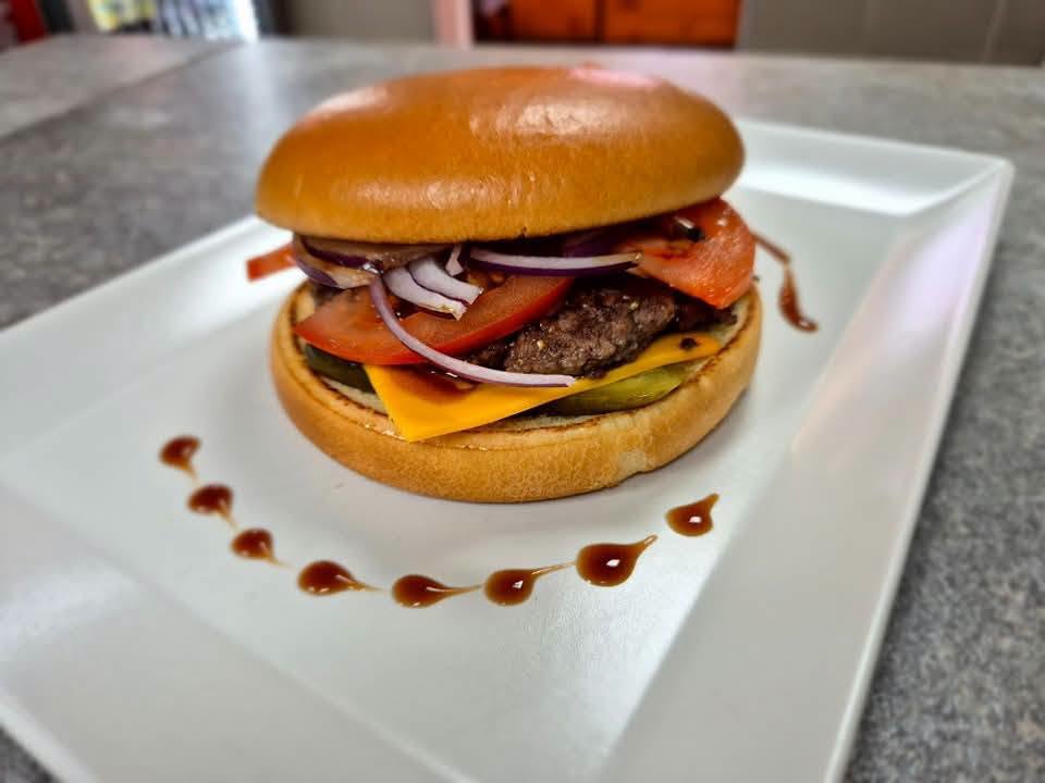 Hamburger zöldségekkel, fehér tányéron az Ilee’s-ben