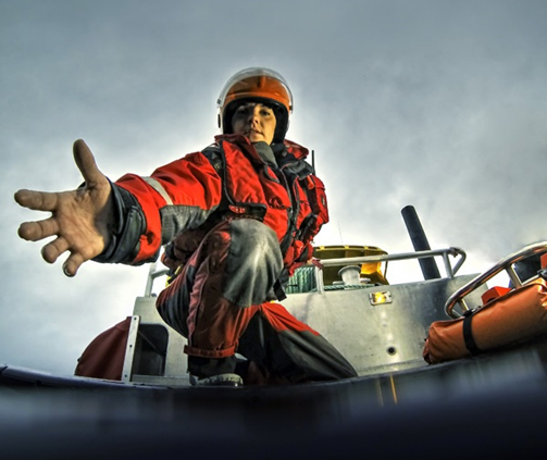 Person dressed in heavy-duty gear extending a hand