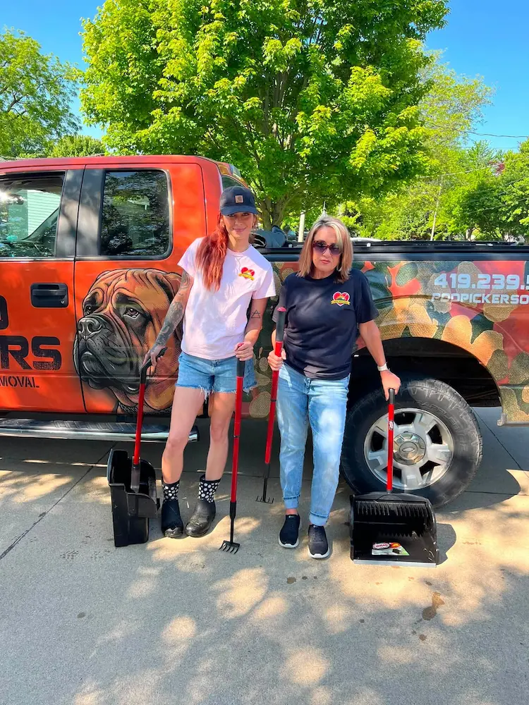 Poo Pickers technician scooping pet waste from a green lawn