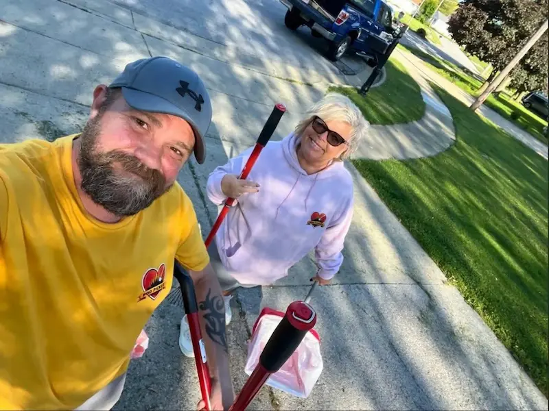 Poo Pickers Ohio team member with a friendly dog after completing yard cleanup