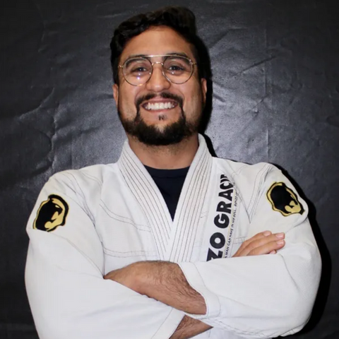 Coach Allan proudly wearing his brown belt as he demonstrates a Brazilian Jiu-Jitsu technique at Renzo Gracie Weston Training Center, where he has been coaching fundamental and drilling classes for the past 6 years since 2015, sharing the expertise he gained from 11 years of dedicated practice in the martial art.