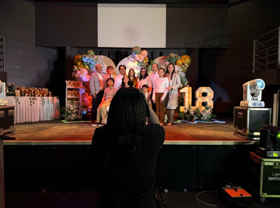 Josel with a camera beside a decorated stage