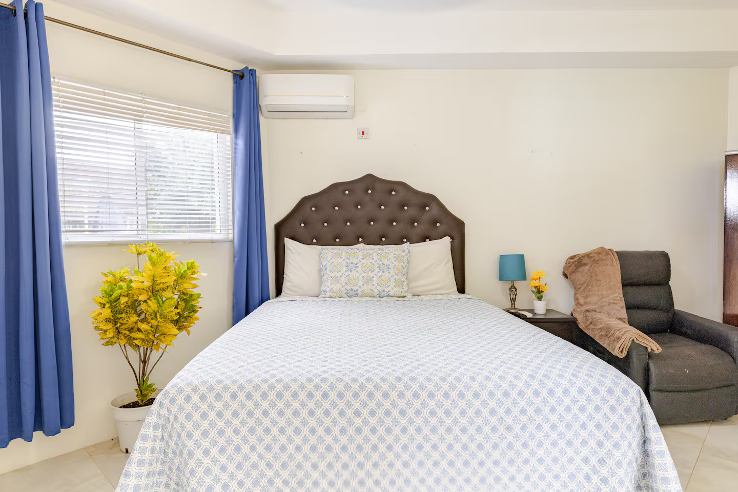 Comfortable Master Bedroom with Tufted Headboard, Air Conditioning & Cozy Armchair