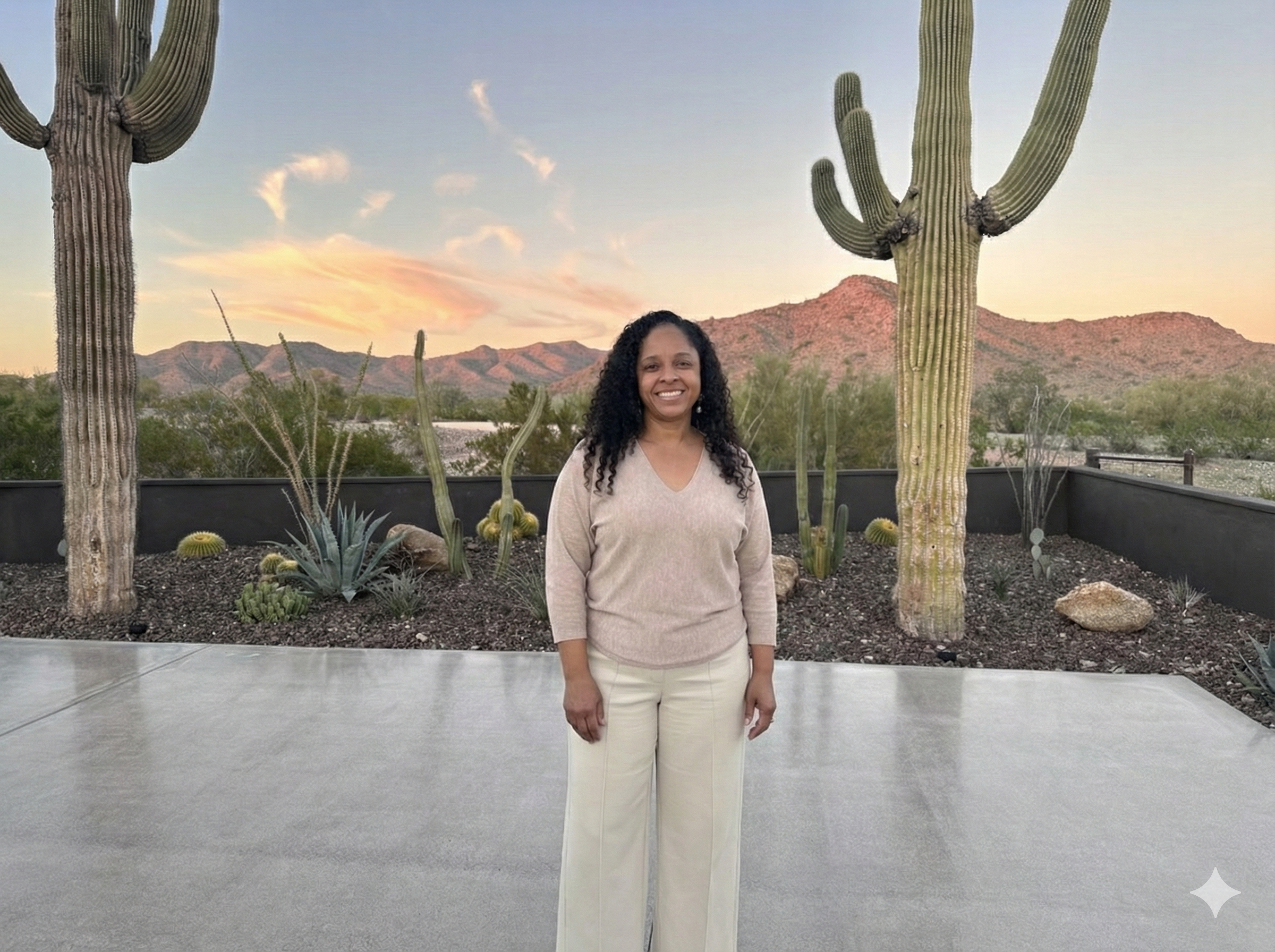 Maggie Truitt smiling in front of saguaro cacti and East Valley mountains at sunset