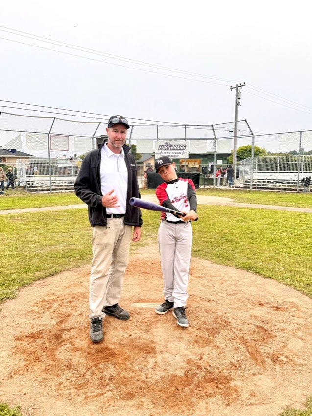 Bodhi standing on a baseball field with his dad Jake Barefoot.