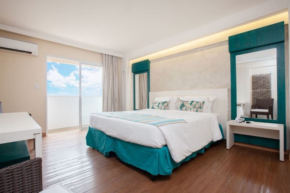 Quarto luxo com cama king e varanda no Hot Beach Celebration