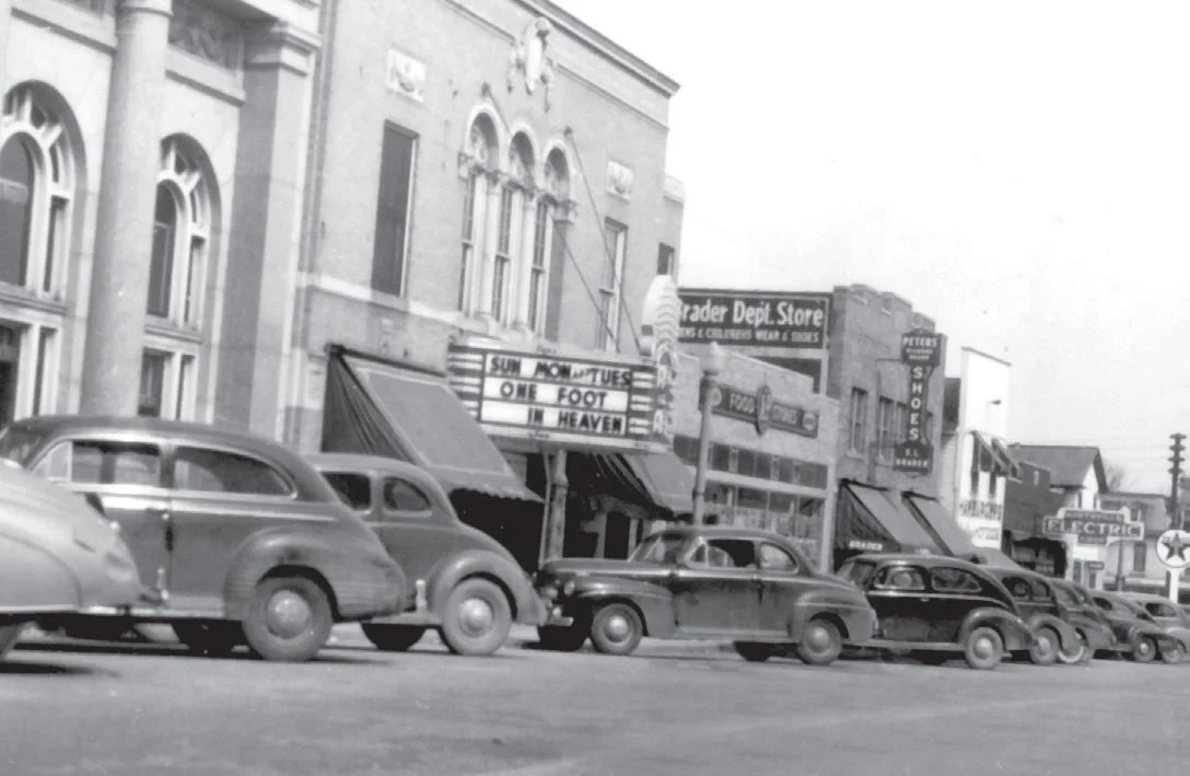 Black and white photo of Penniman-Allen Theater with vintage cars in Northville, MI.