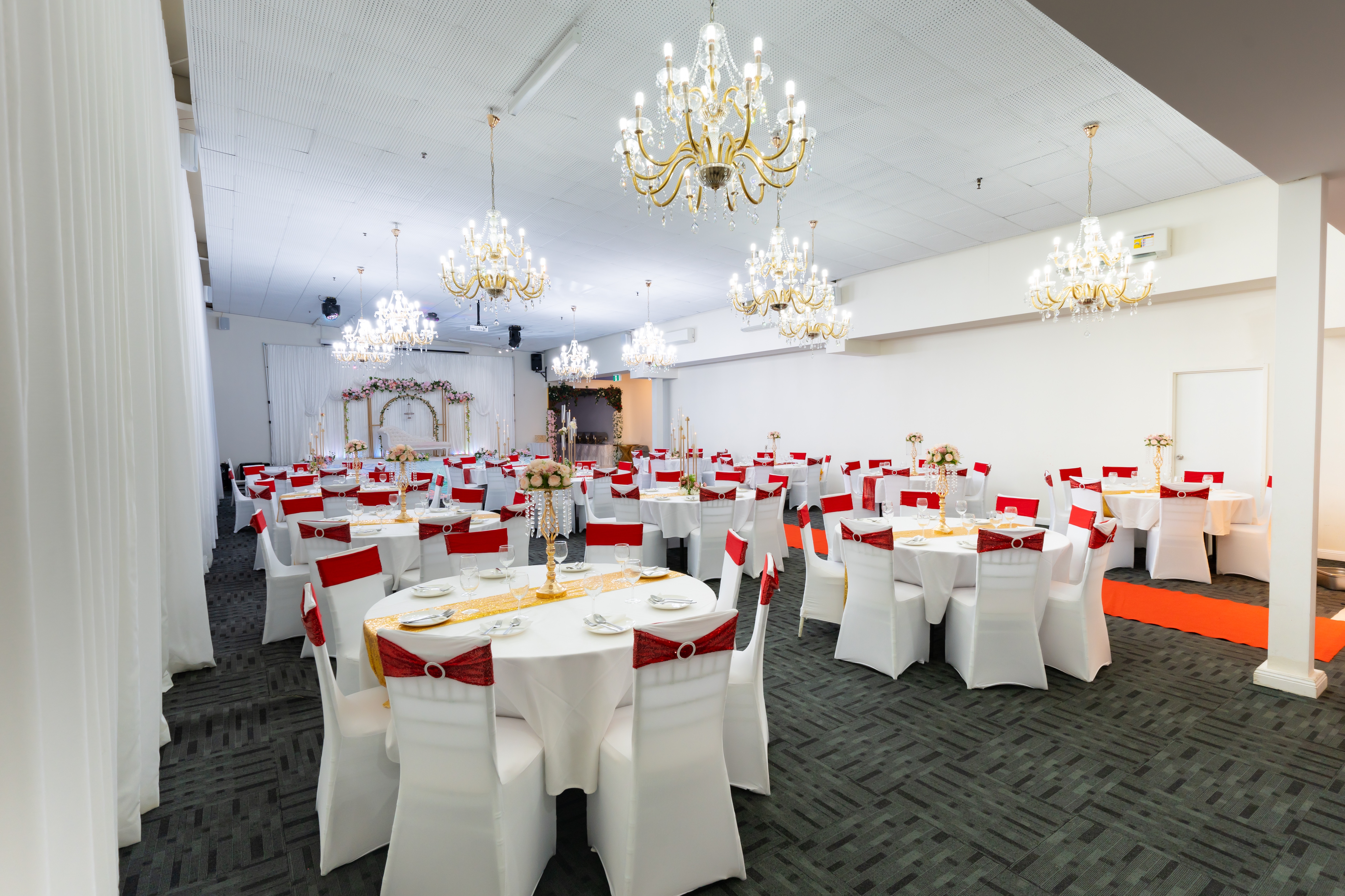 Diamond Hall banquet setup with red accents and chandeliers.