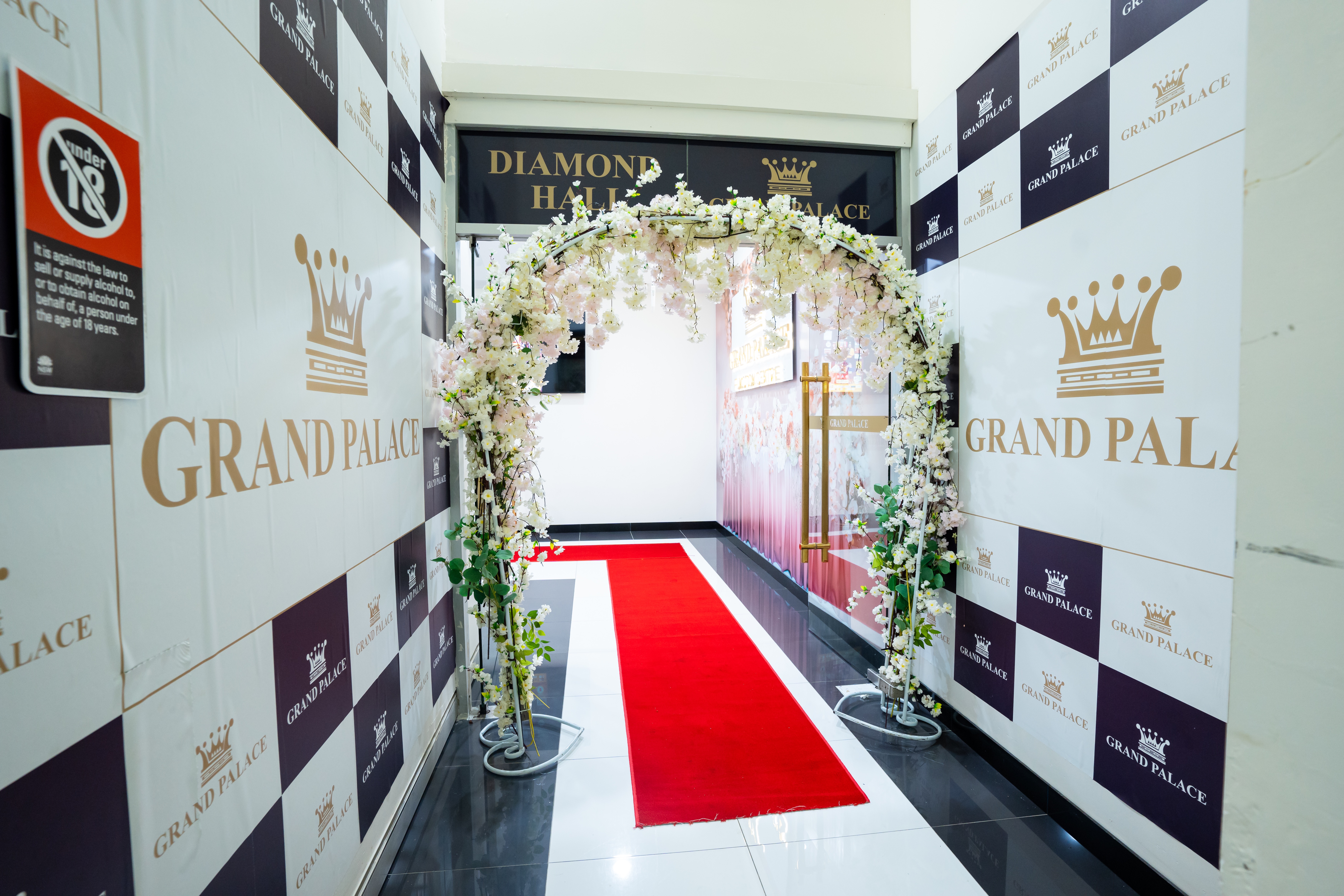 Diamond Hall guest entrance with red carpet and floral arch.