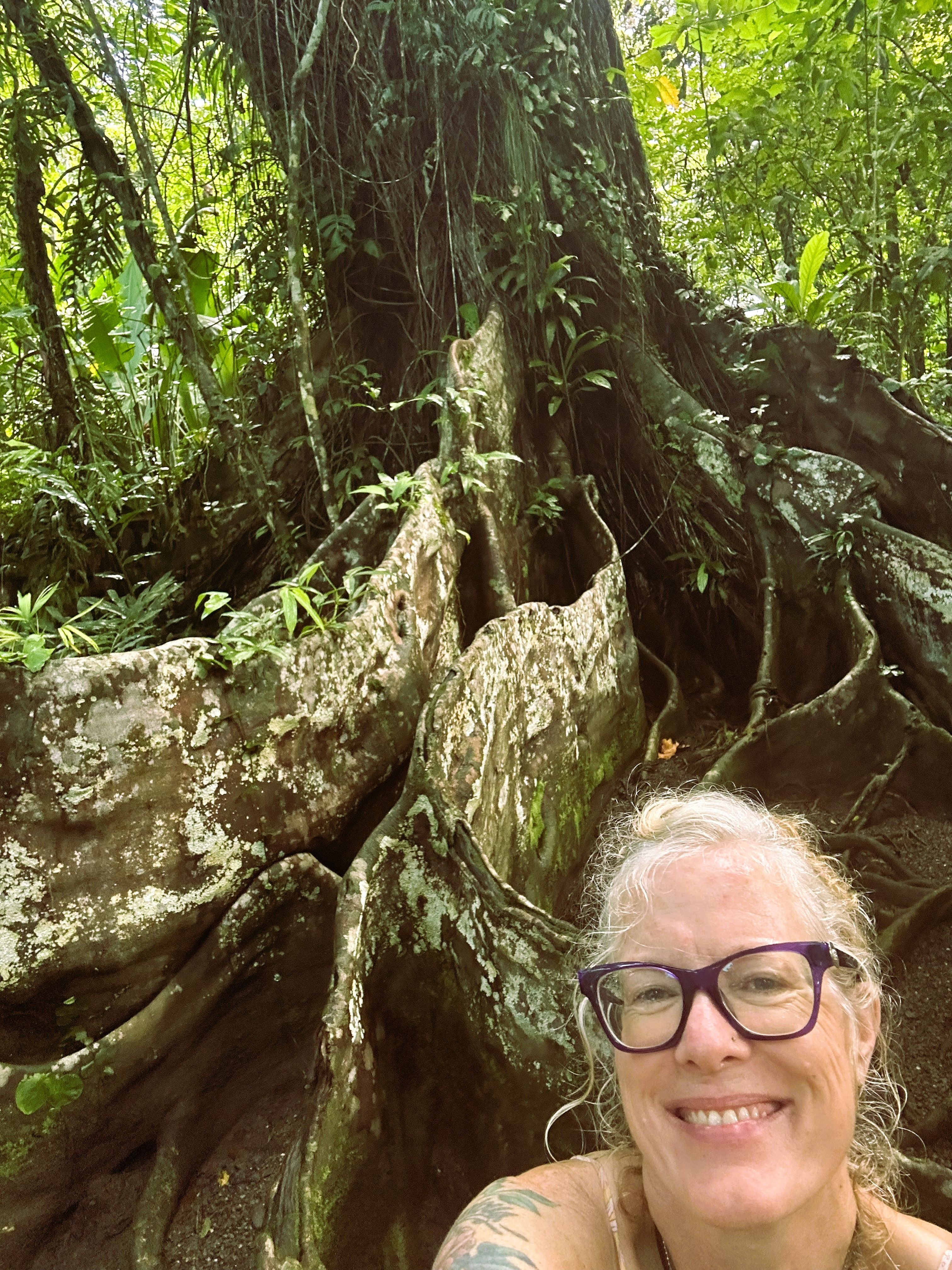 Morgan smiling before an ancient grandmother tree with massive roots — S.H.I.P Costa Rica training, 2024