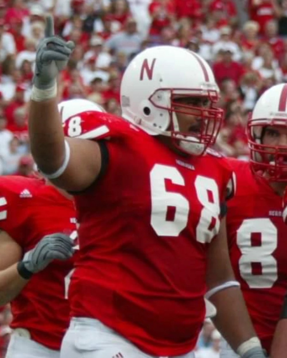 Dan Waldrop in his Nebraska football uniform, number 68, pointing to the crowd