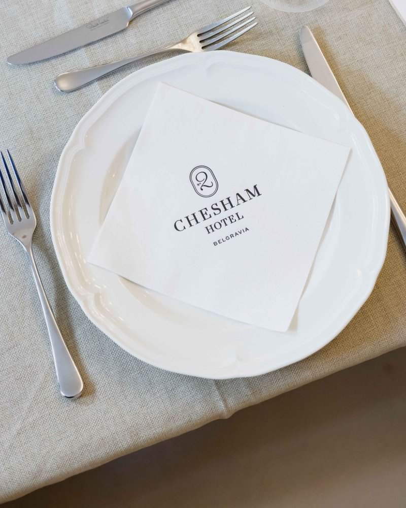 A place setting with a Chesham Hotel napkin at a Founders Freedom lunch