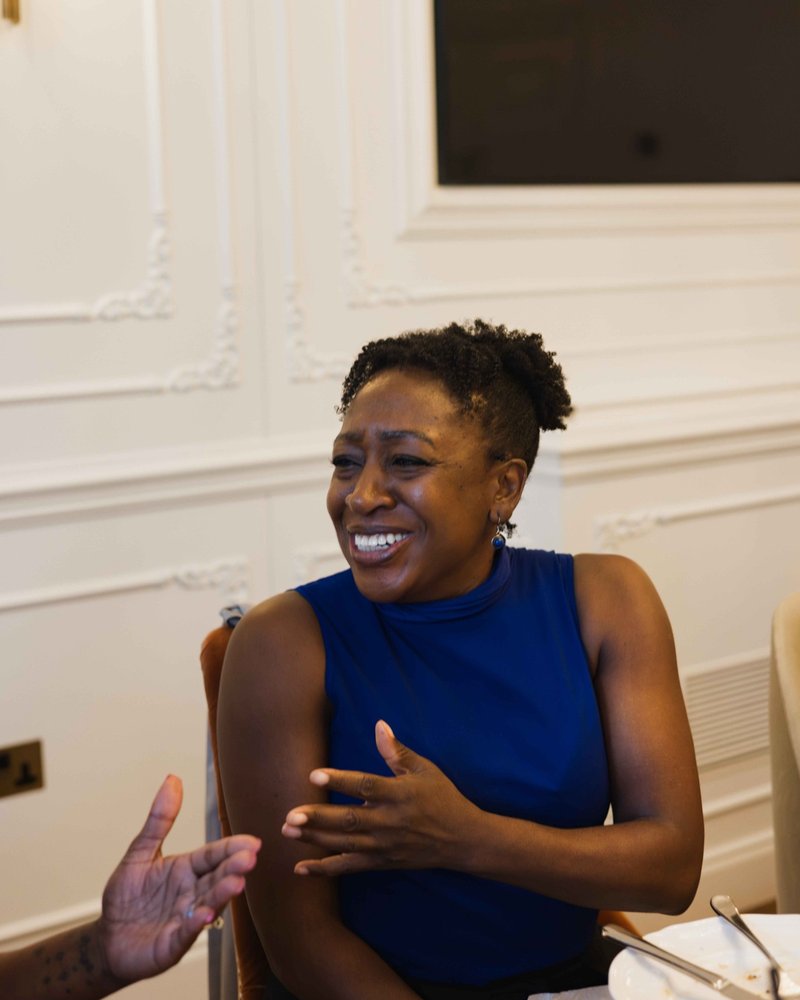 A founder in a blue top laughing mid-conversation at a Founders Freedom gathering
