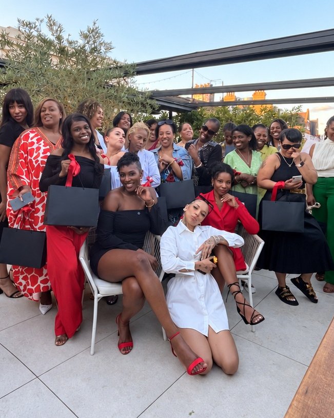 A large group holding Founders Freedom gift bags on a rooftop terrace