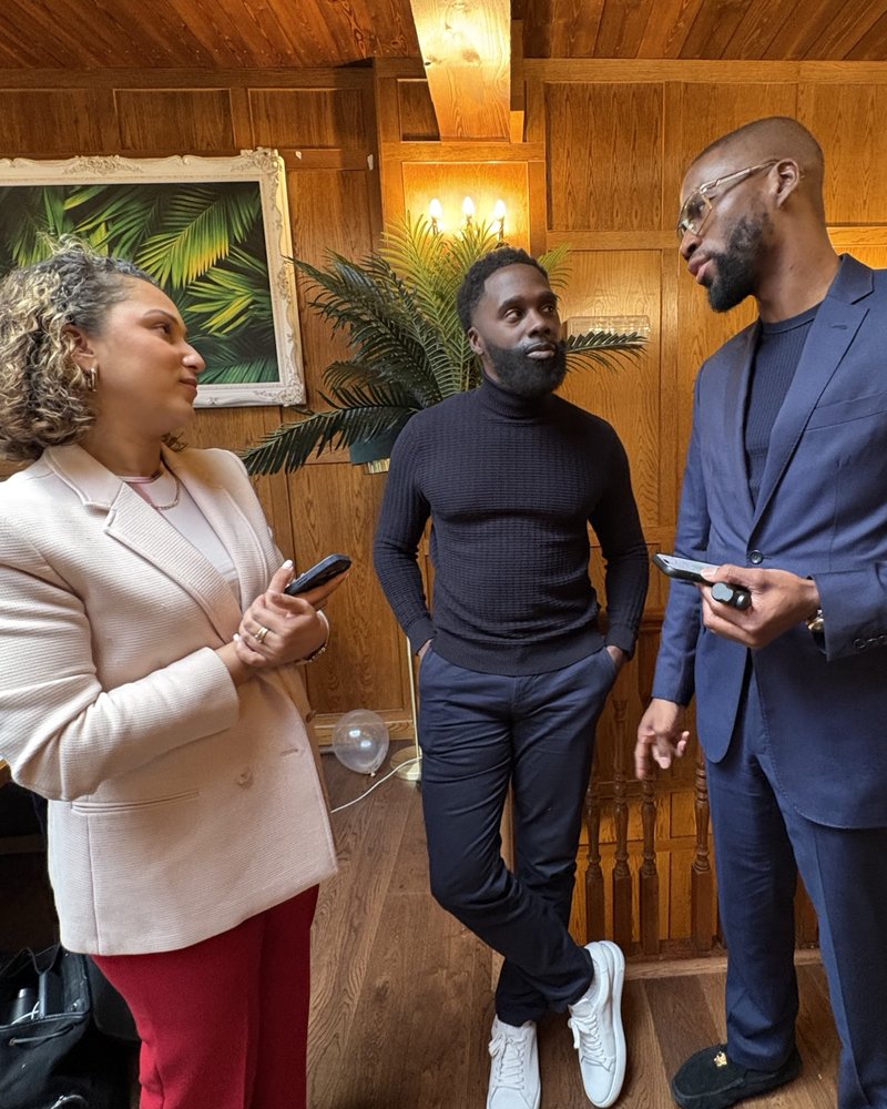 Three people in conversation in a wood-panelled room at a Founders Freedom gathering