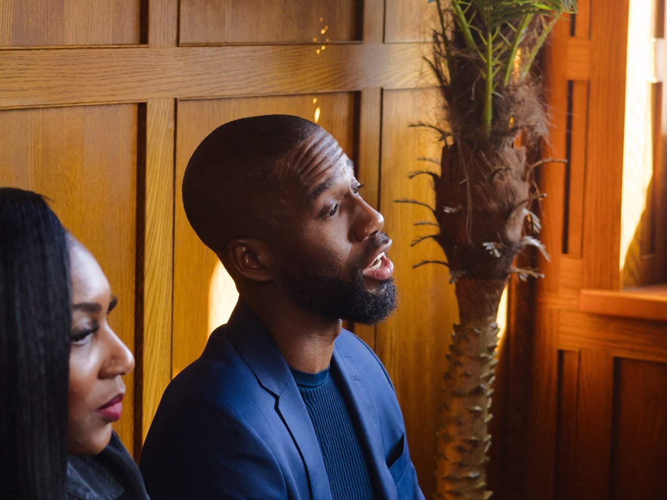 A founder in a blue suit talking with a founder beside him in a warm wood-panelled room at a Founders Freedom Connect gathering