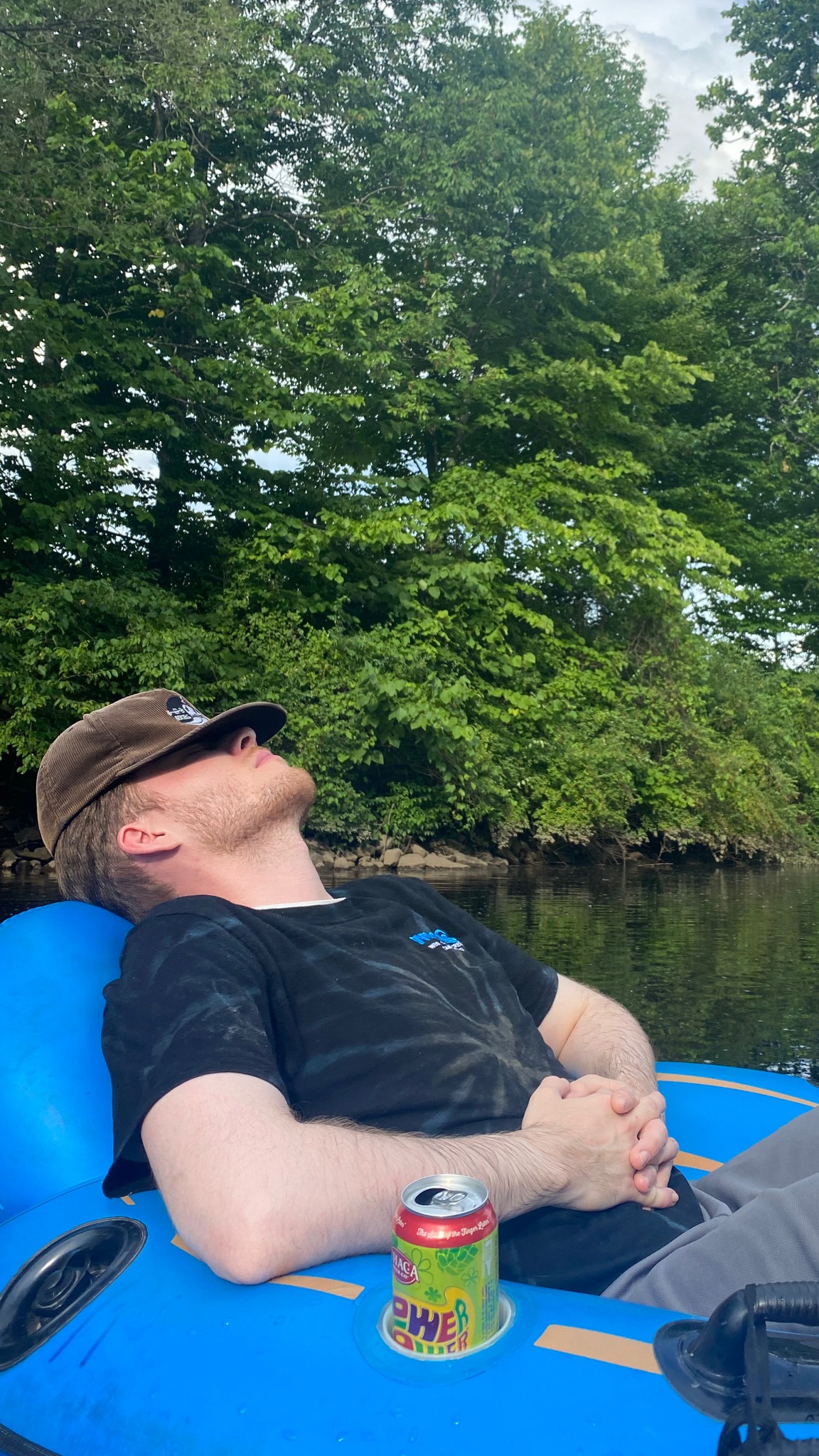 Guest relaxing and napping on a tube floating down West Canada Creek on a summer day