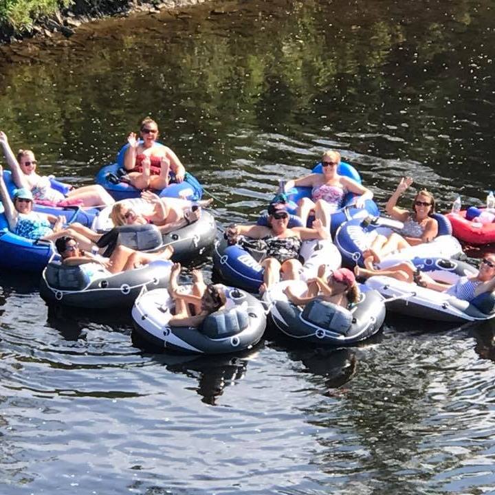 Group of friends tubing together on West Canada Creek near Utica NY on a sunny summer day