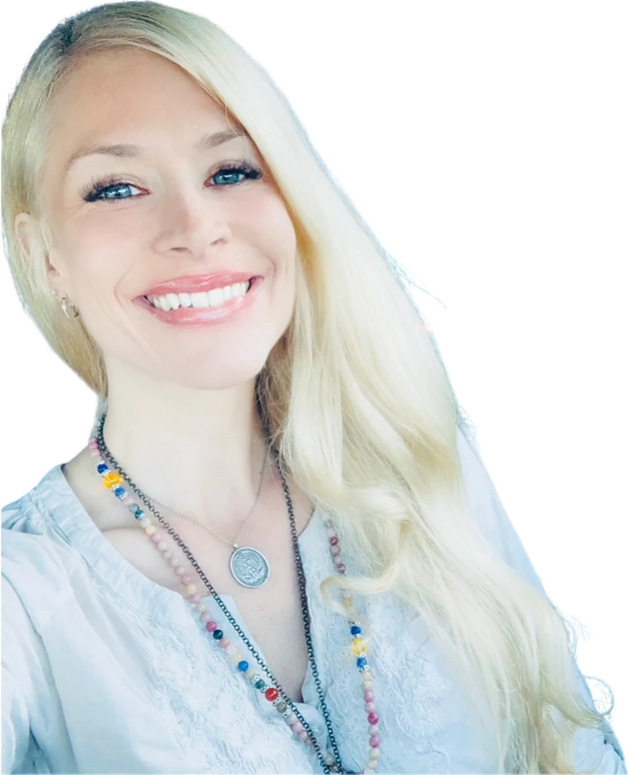 Molly Rose Holmes smiling, long blonde hair, a beaded mala and a silver medallion over a white embroidered blouse