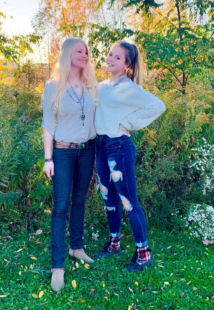 Molly Rose Holmes outdoors among autumn trees with her daughter, both smiling