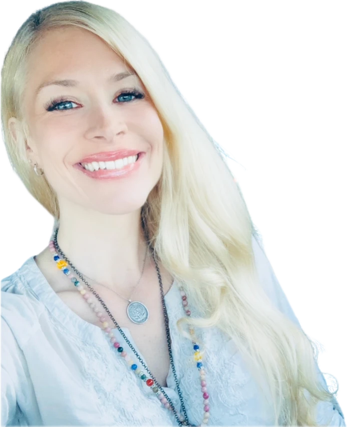 Molly Rose Holmes smiling, long blonde hair, a beaded mala and a silver medallion over a white embroidered blouse