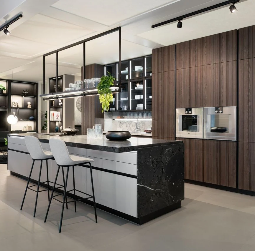 A German Kitchen Center kitchen with bar seating and a black marble island in our showroom