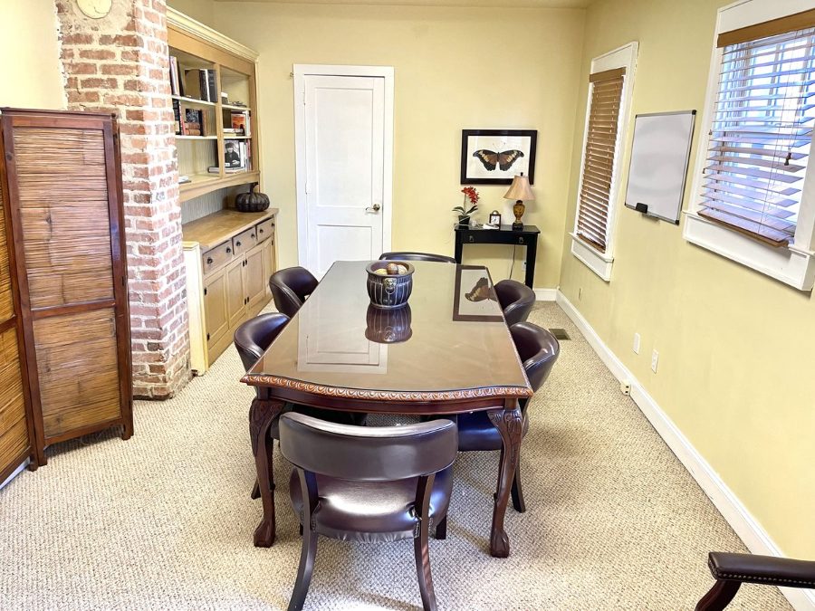 Shared conference room at The 440 with seating for six, exposed brick and built-in bookshelves