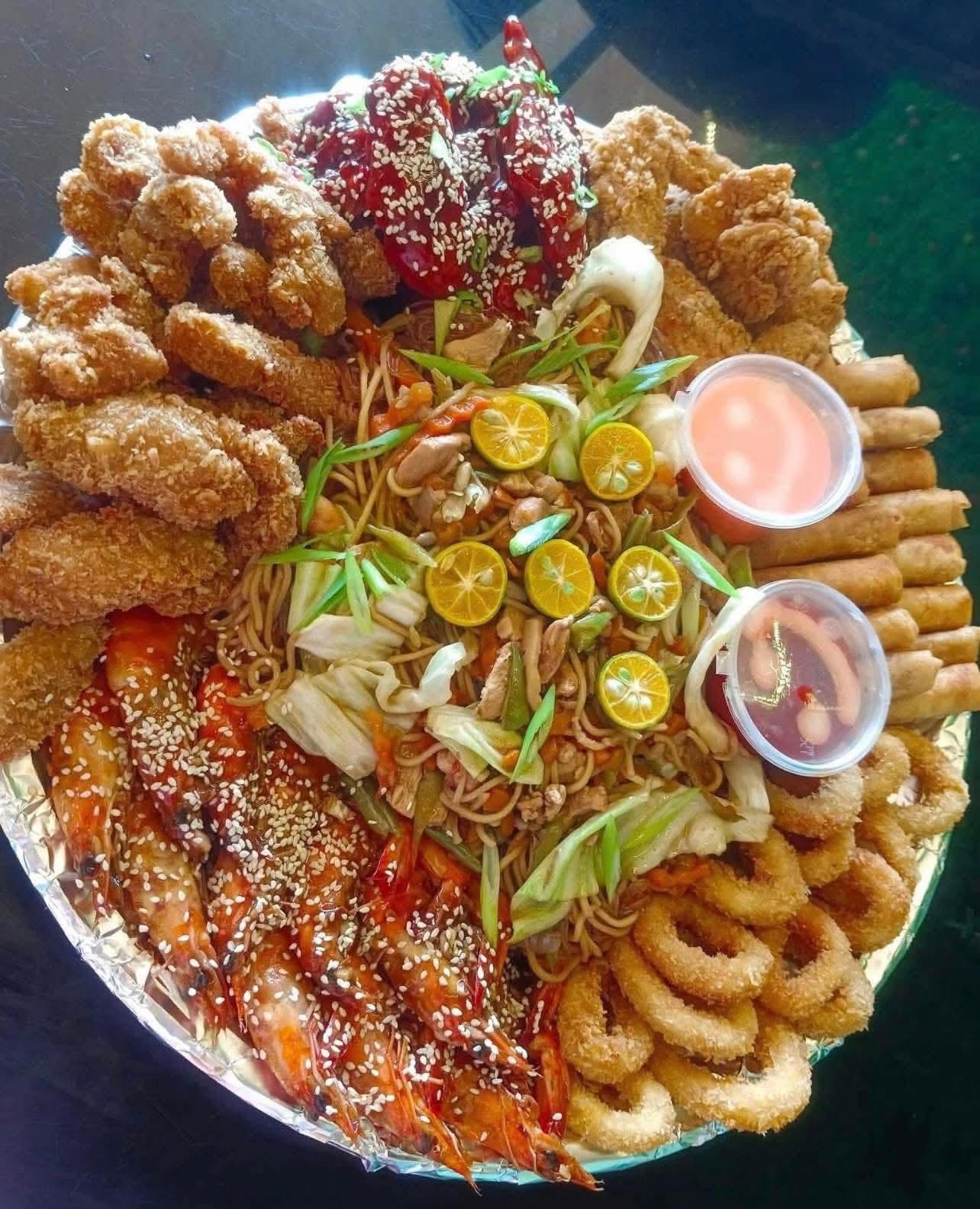 Large platter of pansit, shrimp and assorted crispy food for sharing