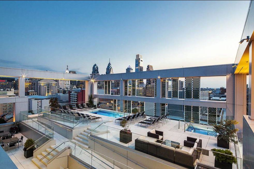 Rooftop pool, lounge seating and Philadelphia skyline