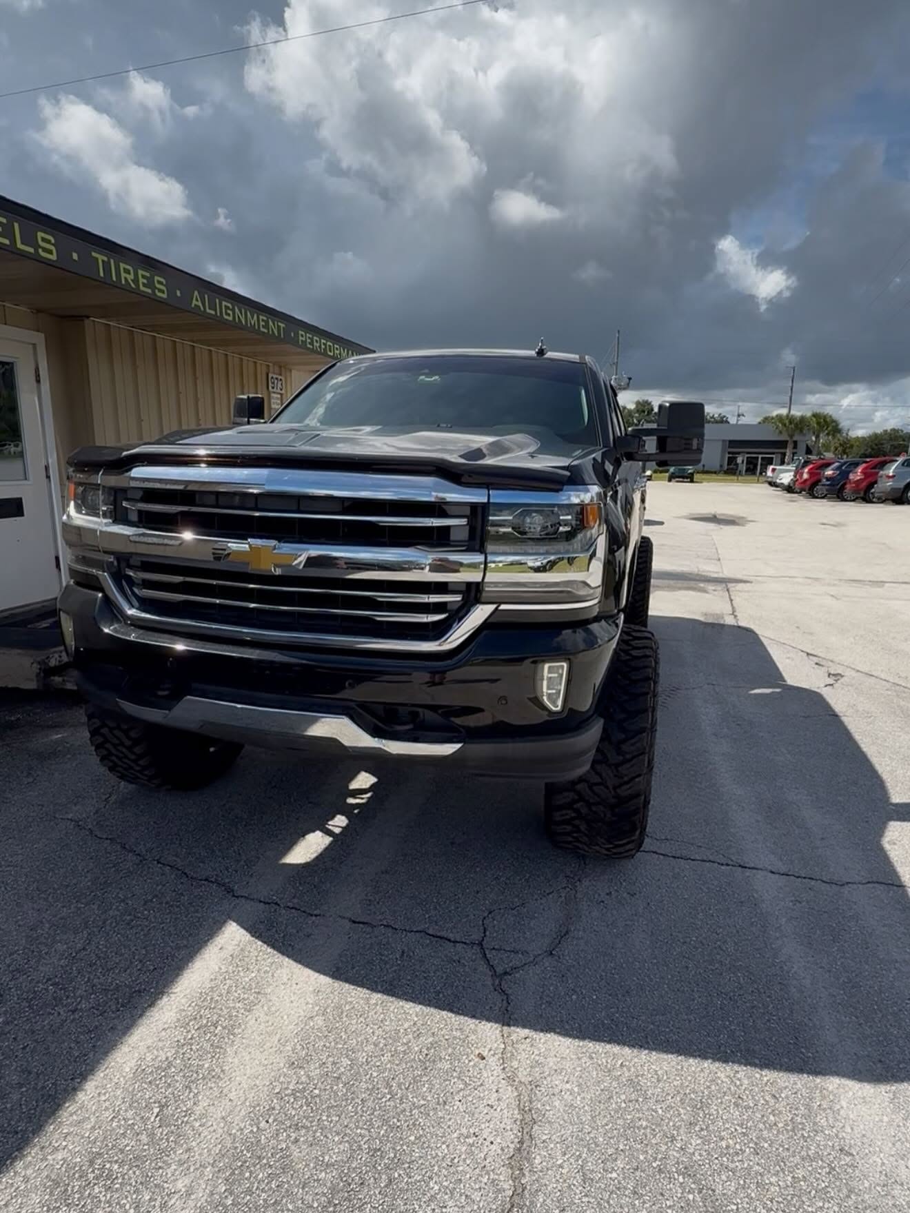 Lifted black Chevy Silverado outside the Top Trucks shop