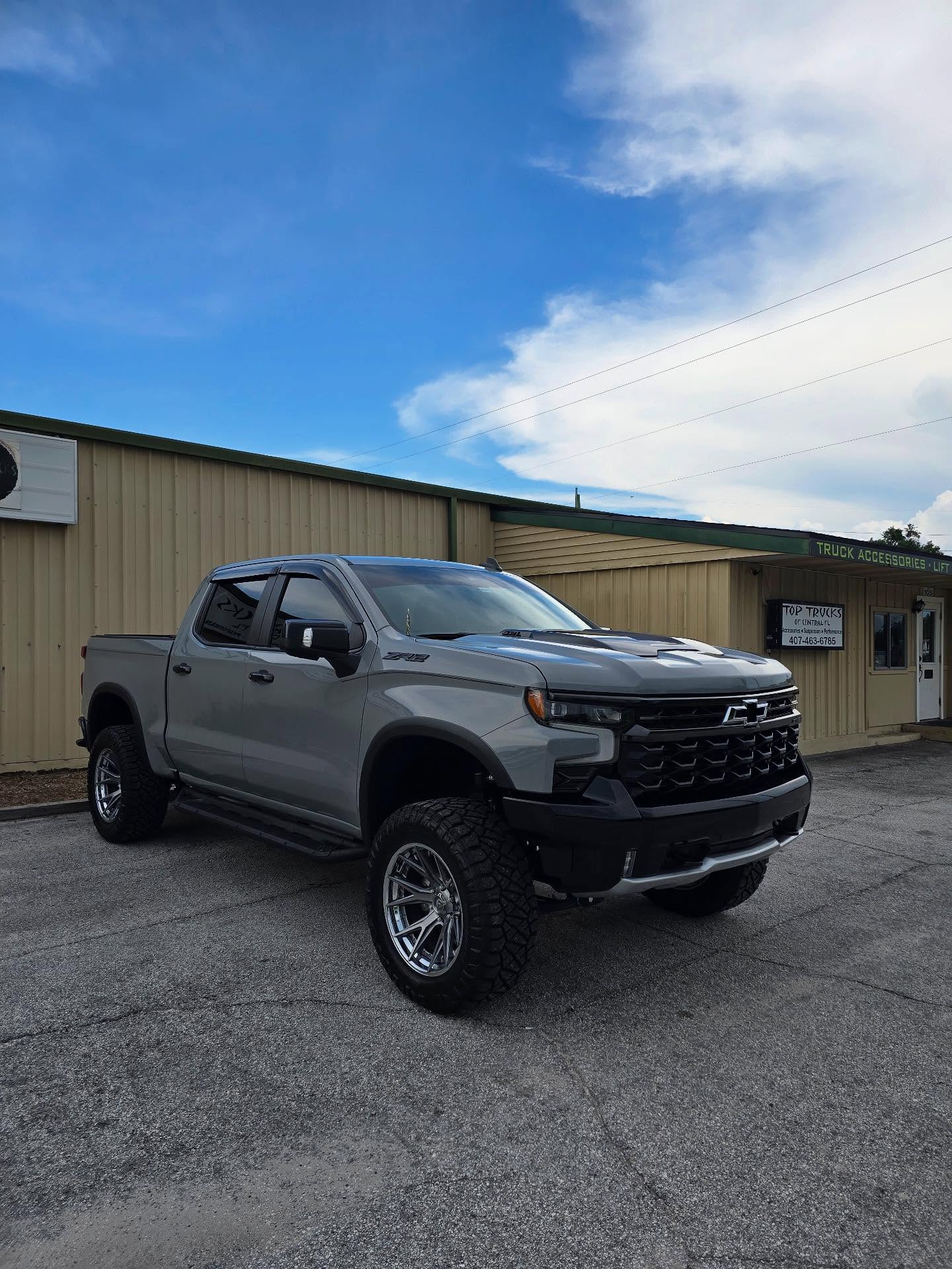 Lifted gray Chevy Silverado ZR2 outside the Top Trucks shop