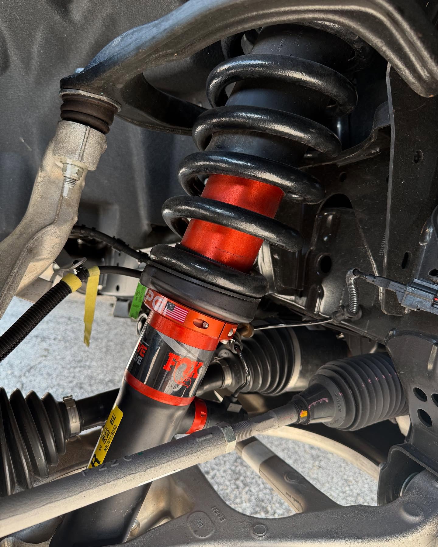 Red coilover suspension, up close, built at Top Trucks of Central Florida in Longwood, FL