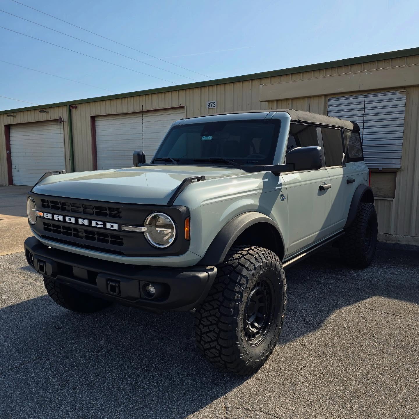 Lifted gray Ford Bronco outside the Top Trucks shop
