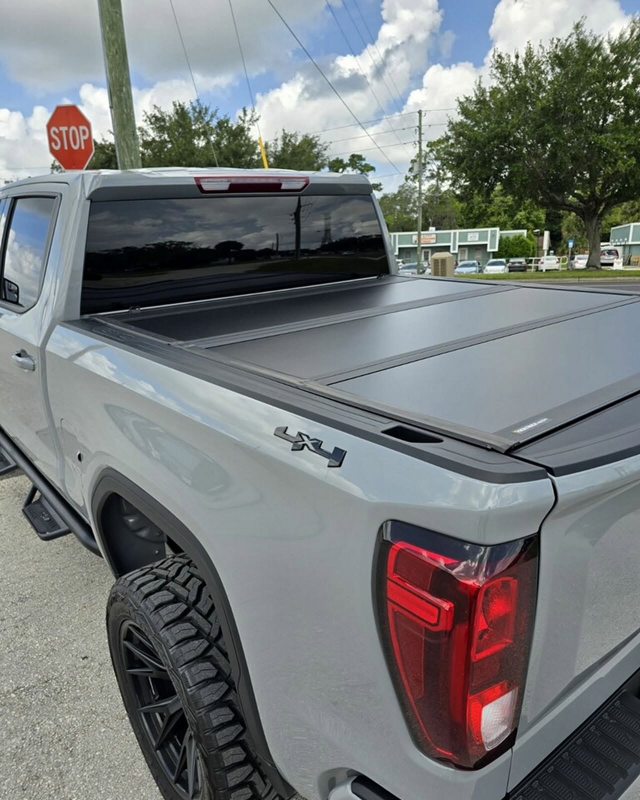 Hard folding bed cover on a lifted gray pickup