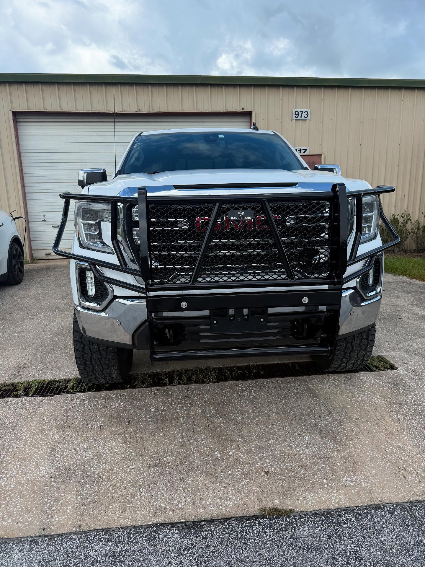 GMC Sierra with a grille guard outside the Top Trucks shop
