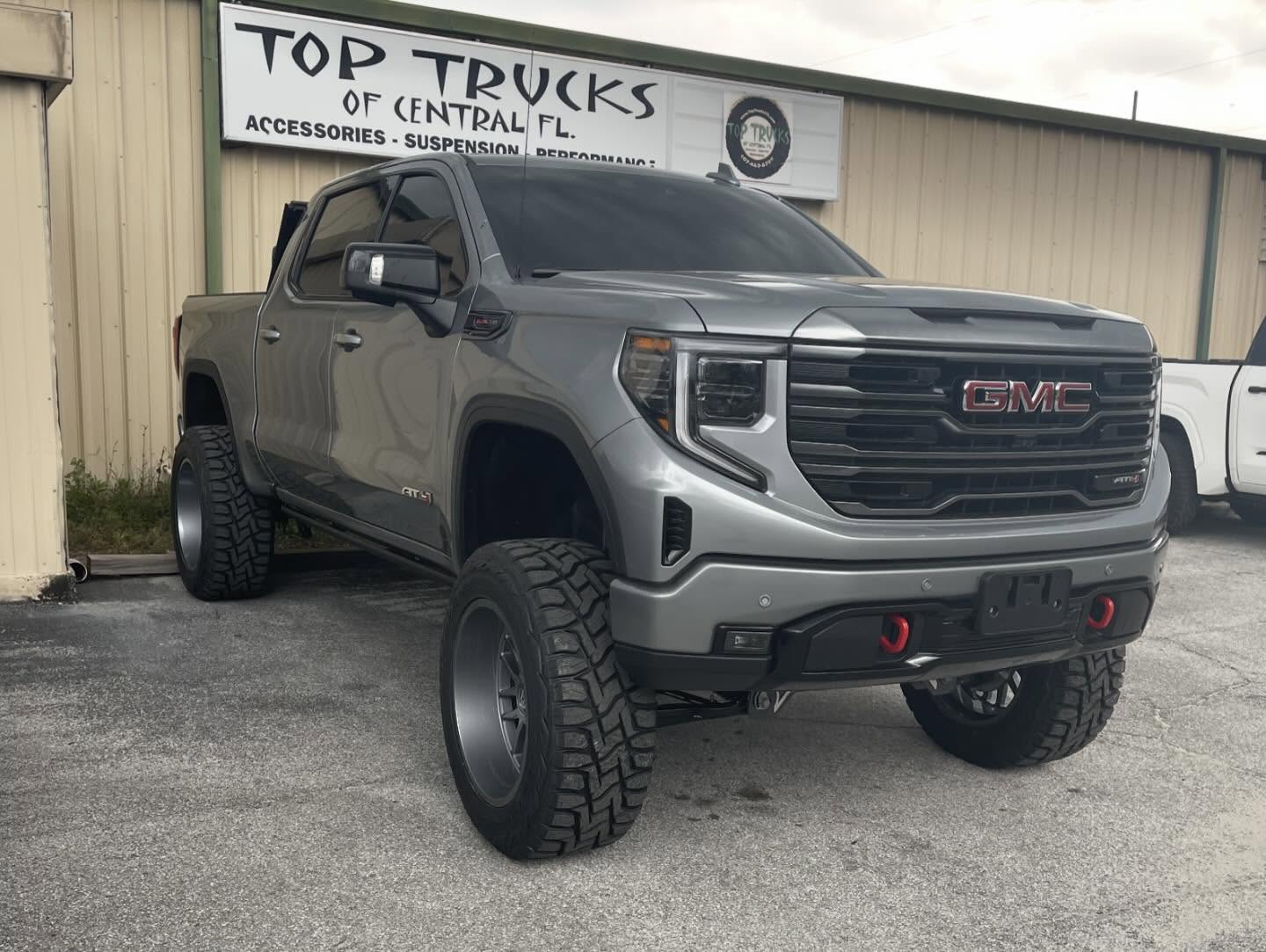 GMC Sierra AT4 with a lift kit and black wheels, built at Top Trucks