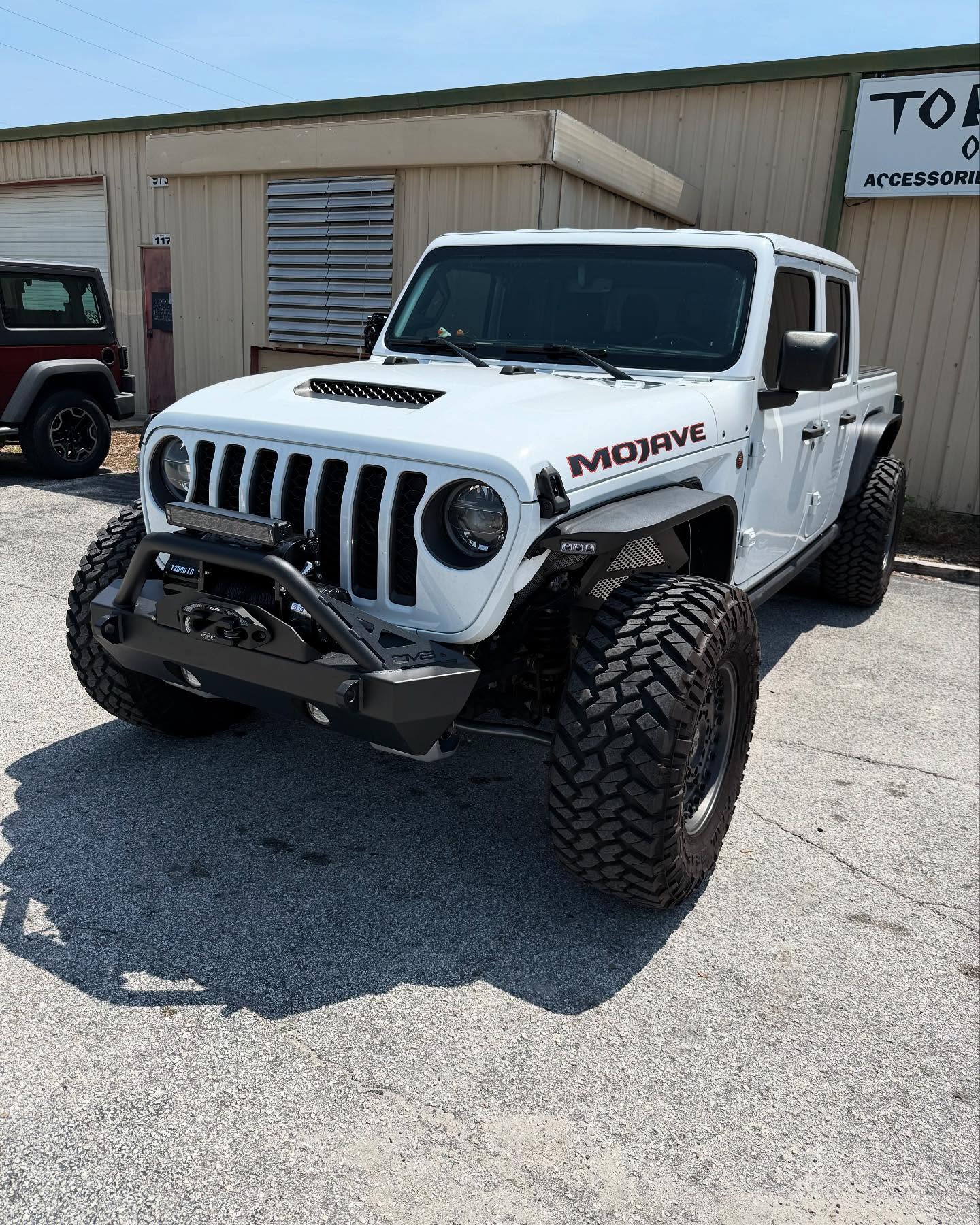 White Jeep Gladiator Mojave outside the Top Trucks shop