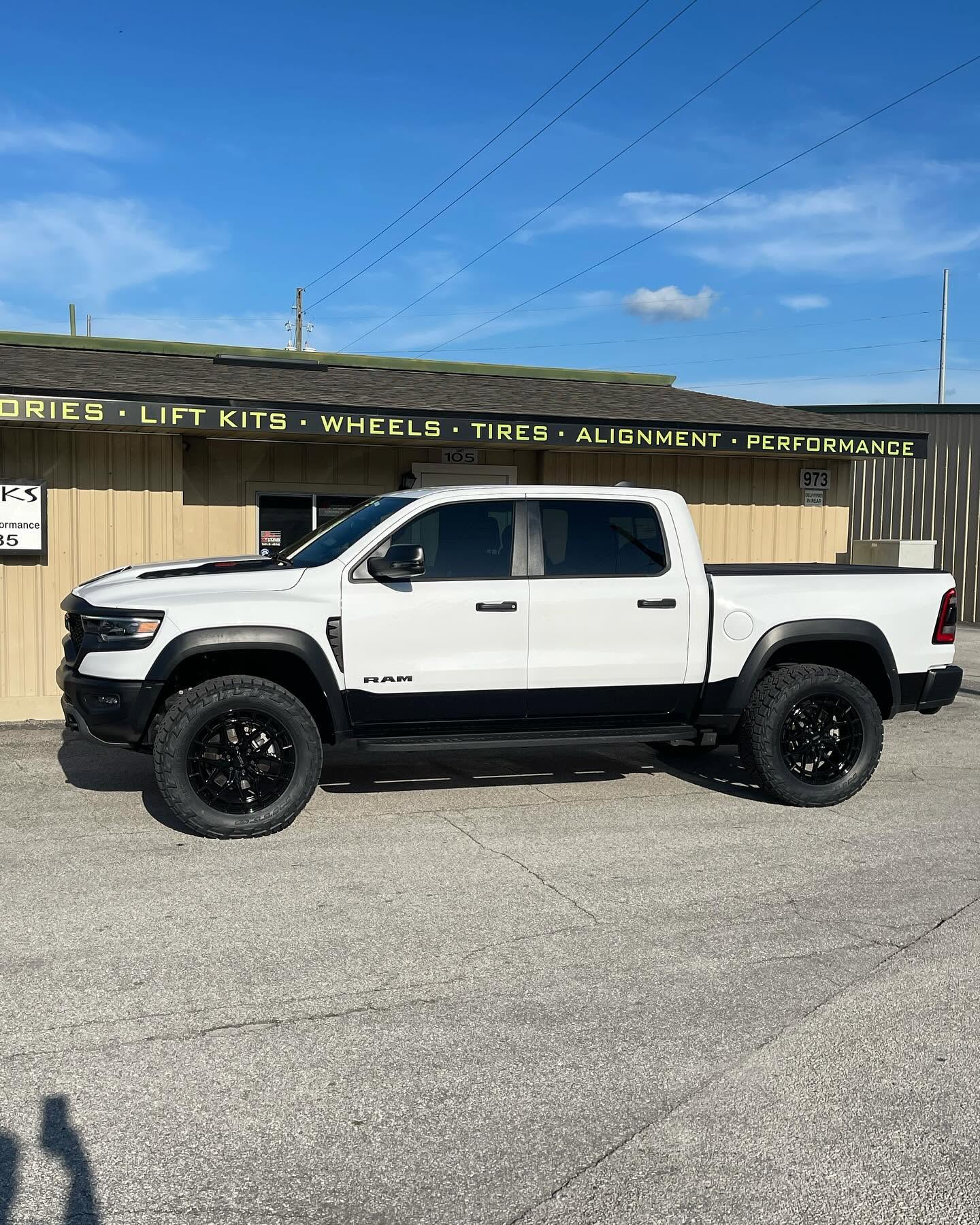White Ram TRX on black wheels outside the Top Trucks shop