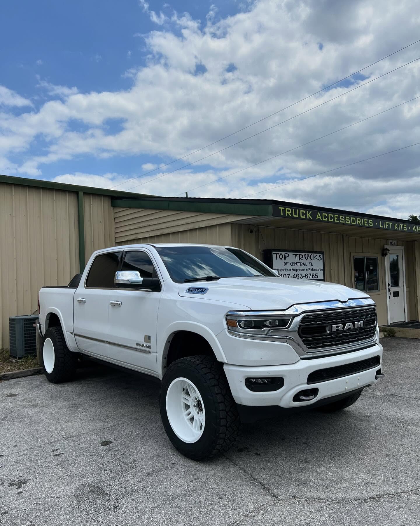 White Ram 1500 on white wheels outside the Top Trucks shop