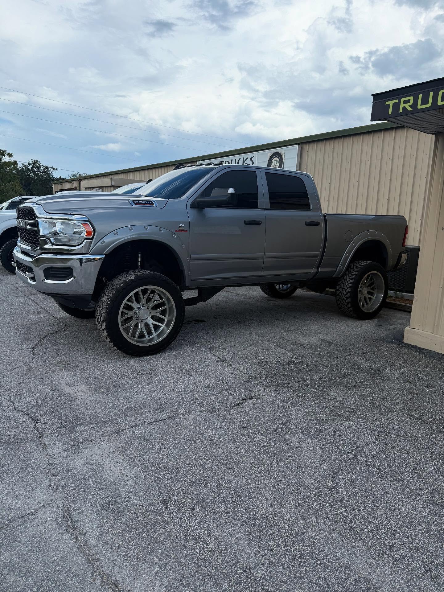 Lifted gray Ram 2500 outside the Top Trucks shop