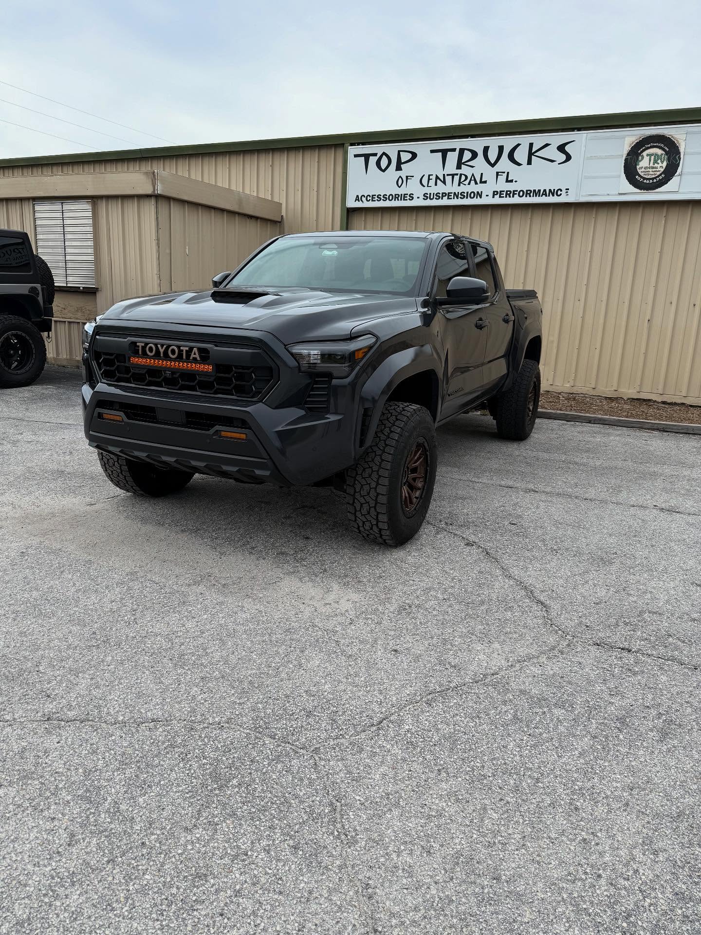 Black Toyota Tacoma on bronze wheels, built at Top Trucks of Central Florida in Longwood, FL