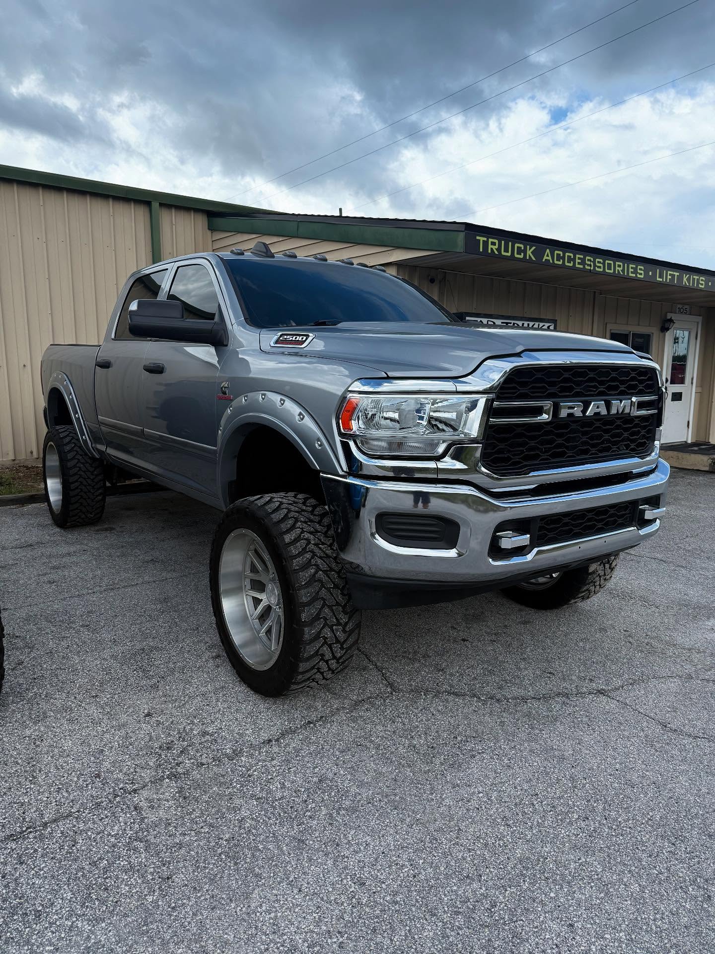 Lifted gray Ram 2500 outside the Top Trucks shop