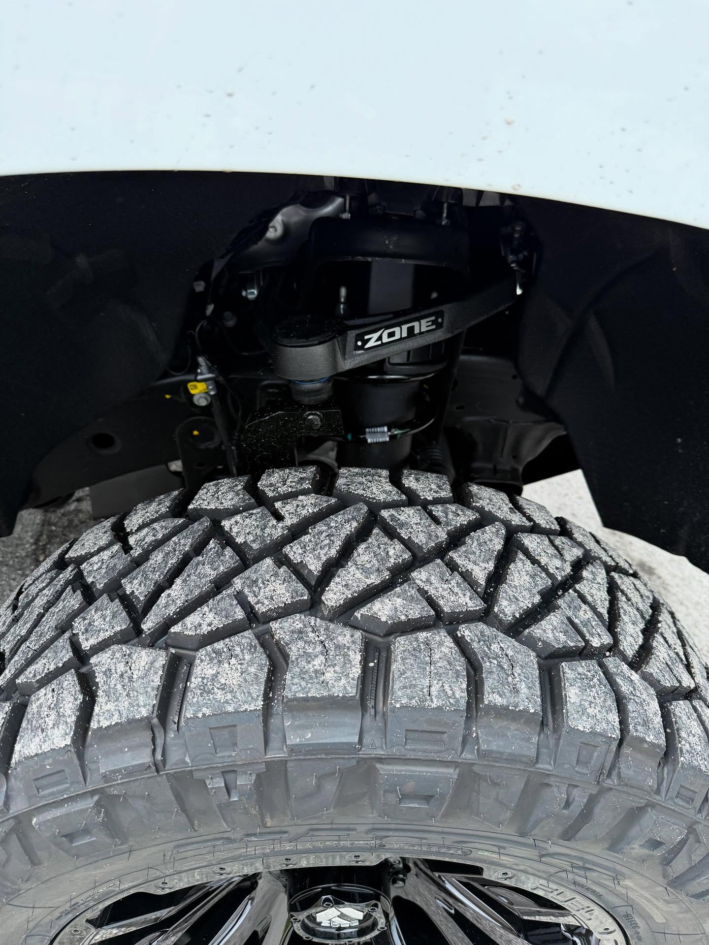 Zone Offroad coilover behind an all-terrain tire, built at Top Trucks of Central Florida in Longwood, FL