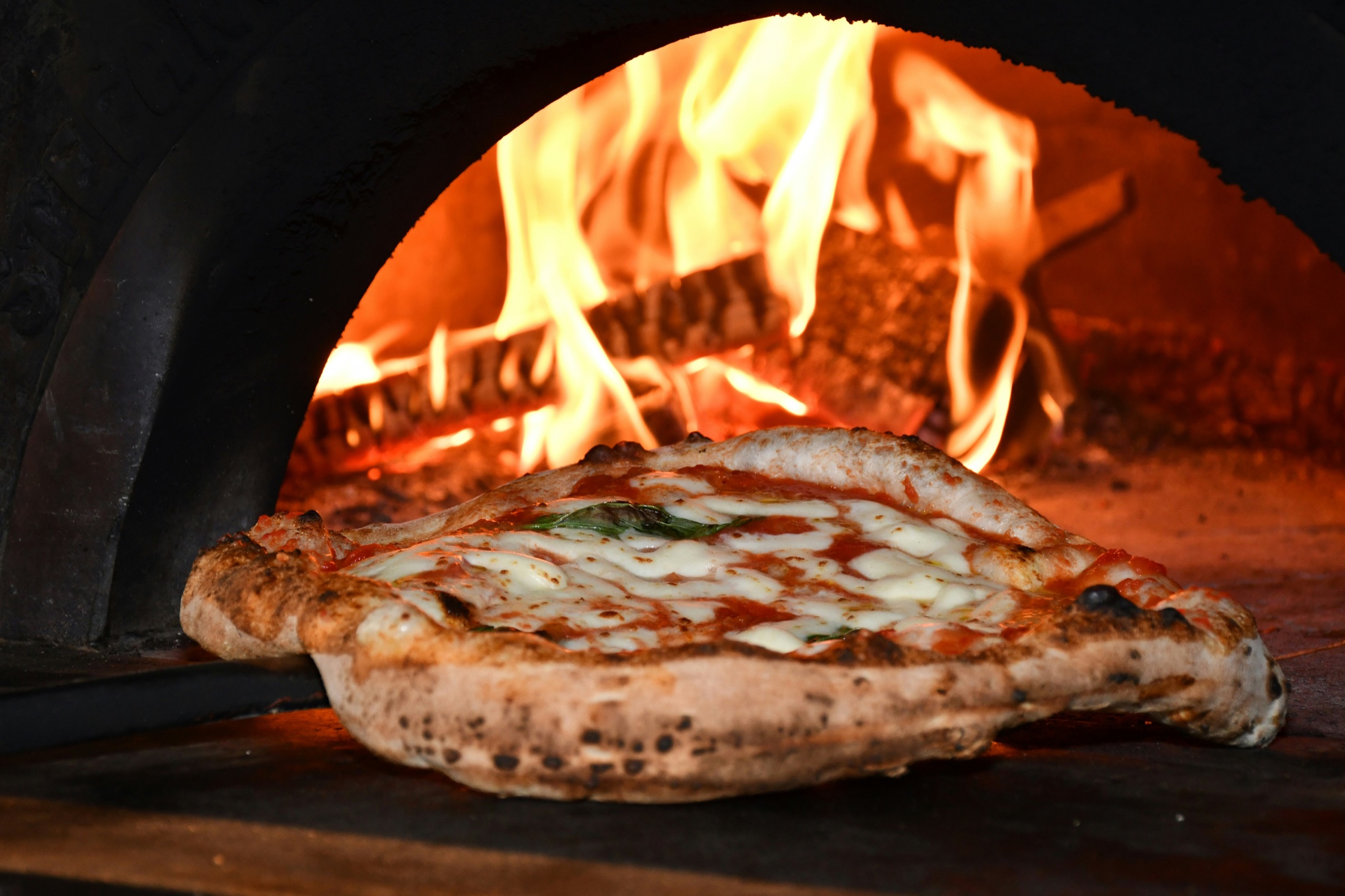 A wood-fired pizza inside an IglOven