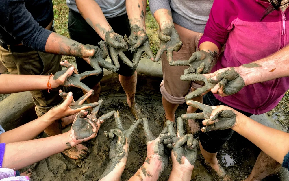 muddy hands are making peace signs in a circle after field. work for NGOs in Guatemala muddy hands are making peace signs in a circle after field. work for NGOs in Guatemala